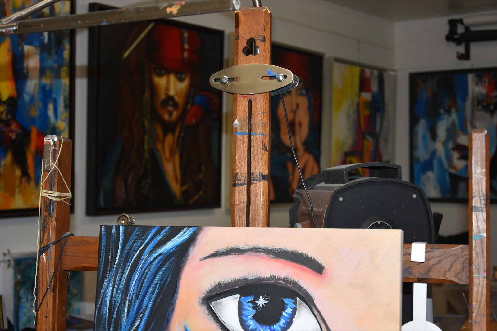 Mur d'atelier de Sabine Vandermouten, toiles figuratives et abstraites côte à côte