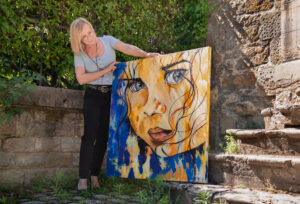 Sabine Vandermouten et une toile en cours dans l'atelier